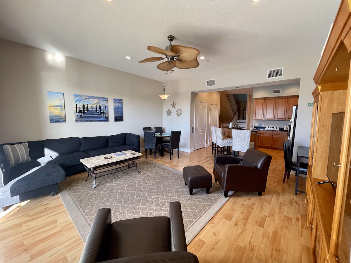 Open living and dining area with coastal art and stairs to upper level