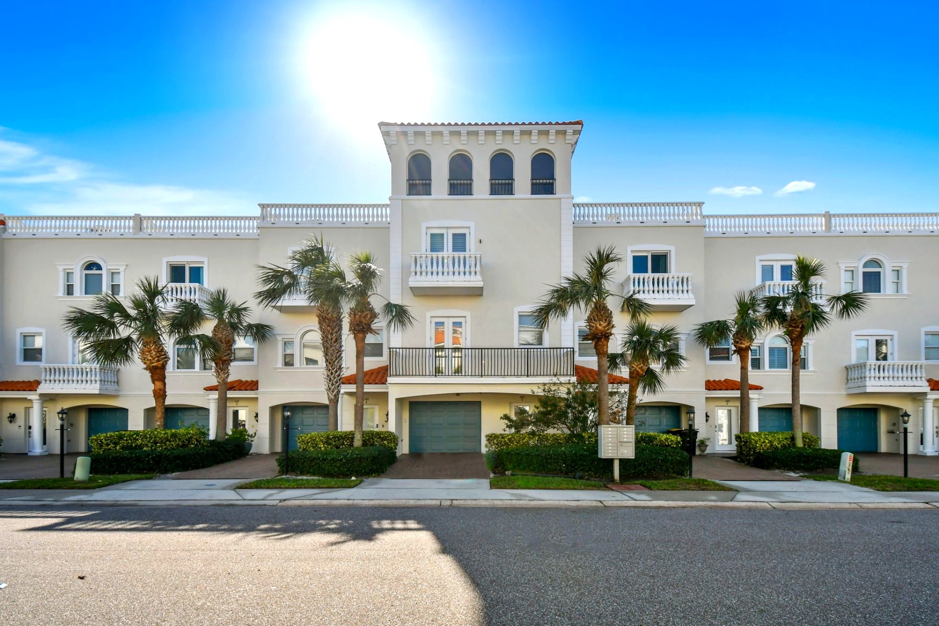 Mediterranean-style facade of Paradise Cove townhomes with palms