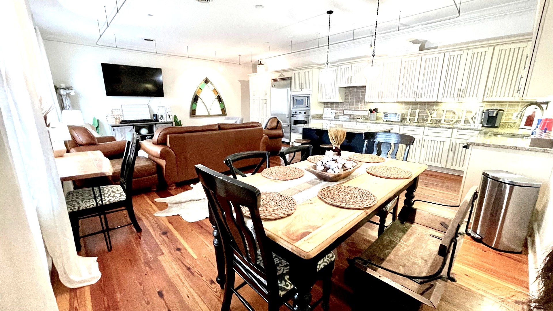 Dining table and open kitchen with Viking appliances and pine floors